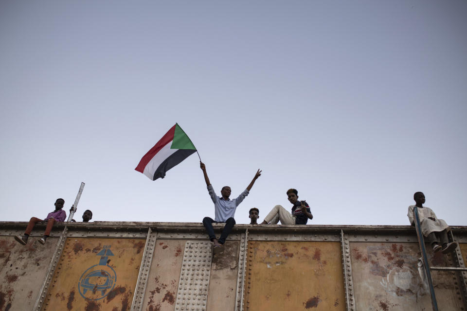 A protester waves a Sudanese national flag during a sit-in at Armed Forces Square in Khartoum, Sudan, Saturday, April 27, 2019. The Umma party of former Prime Minister Sadiq al-Mahdi, a leading opposition figure, said the protesters will not leave until there is a full transfer of power to civilians. (AP Photos/Salih Basheer)