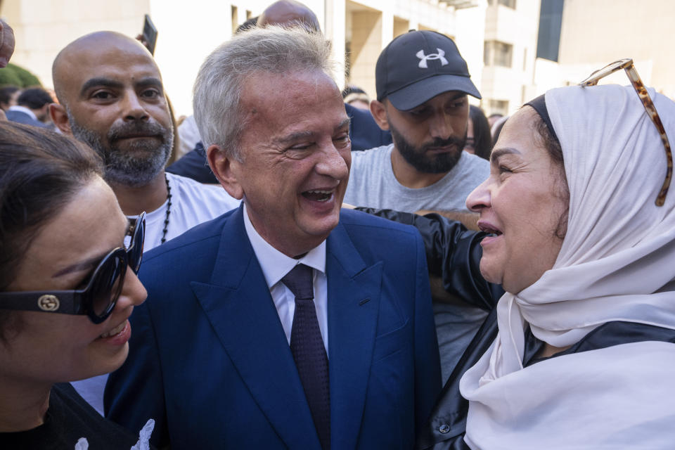 Riad Salameh, center, Lebanon's outgoing Central Bank governor, greets employees at a farewell ceremony marking the end of his 30 years in office outside the Central Bank building, in Beirut, Monday, July 31, 2023. Meanwhile, his four vice governors, led by incoming interim governor Wassim Mansouri, urged the cash-strapped country's government for fiscal reforms at a news conference in that same building. (AP Photo/Hassan Ammar)