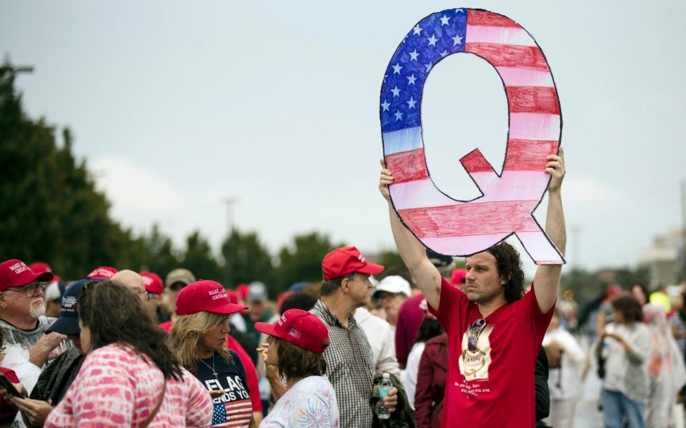 Protesters holds a Q sign waits in line with others to enter a campaign rally with President Donald Trump  - Matt Rourke/Matt Rourke Source: AP