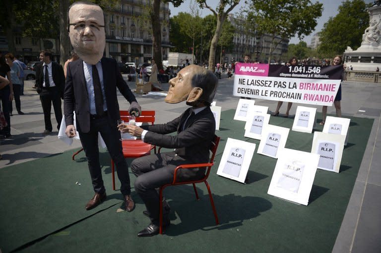 Activists from international solidarity group Avaaz, wearing masks of French President Francois Hollande (L) and Myanmar President Thein Sein, protest in Paris on July 17, 2013 against the visit to France of the Myanmar leader