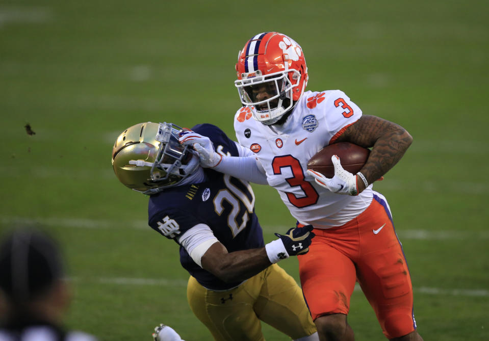 Clemson wide receiver Amari Rodgers (3) fends off Notre Dame safety Shaun Crawford (20) as he runs for a first down during the first half of the Atlantic Coast Conference championship NCAA college football game, Saturday, Dec. 19, 2020, in Charlotte, N.C. (AP Photo/Brian Blanco)