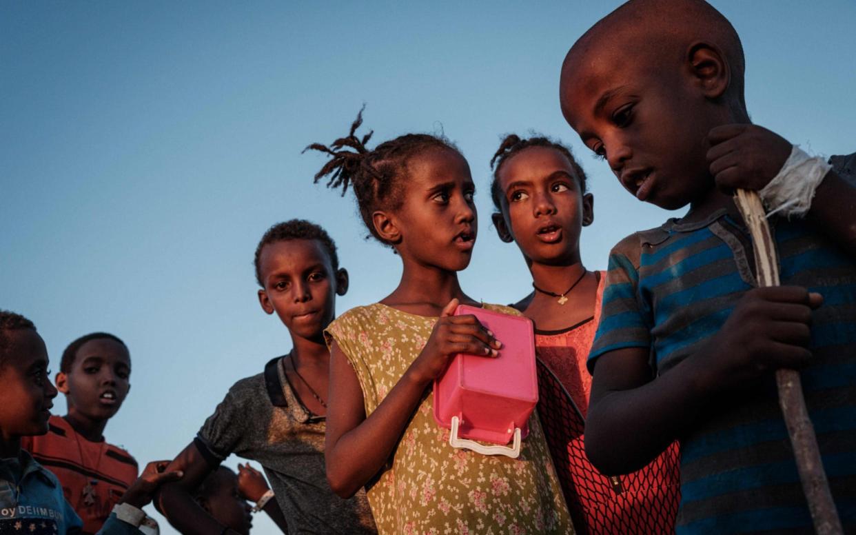 Ehiopian children, who fled the Ethiopia's Tigray conflict as refugees, wait for food distribution in the Um Raquba refugee camp - YASUYOSHI CHIBA /AFP