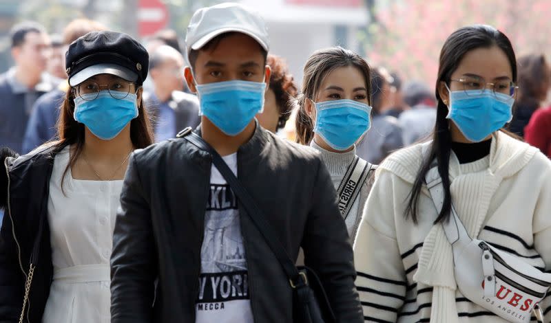 Tourists wear protective masks while visiting Hoan Kiem lake in Hanoi