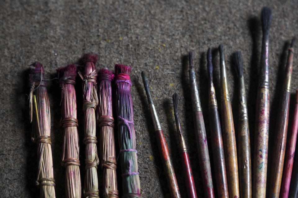 In this July 31, 2019, photo, handmade traditional brushes, left, are lined up along with modern paint brushes at the residence of Chitrakar couple Tej Kumari and Purna, in Bhaktapur, Nepal. Chitrakar families in the Nepalese capital of Kathmandu were renowned traditional painters and sculptors who depicted gods and goddesses on temples, masks of Hindu deities and posters for various religious celebrations. For the Chitrakar couple it is a struggle to keep the dying art alive against the modern mass produced prints. (AP Photo/Niranjan Shrestha)