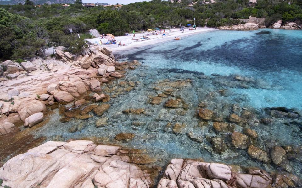 A small group of tourists gather on a beach in Sardinia - Emanuele Perrone/Getty Images Europe