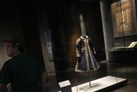 A visitor stands near a coat from India at the Museum of Islamic Art in Doha, Qatar, Tuesday, Nov. 22, 2022. For many of the visitors descending on Qatar for The World Cup, Doha's Museum of Islamic Art provides a peek into diverse aspects of Muslim heritage, art and craftmanship. The collection at MIA, as the museum is known, spans three continents and many centuries. (AP Photo/Christophe Ena)