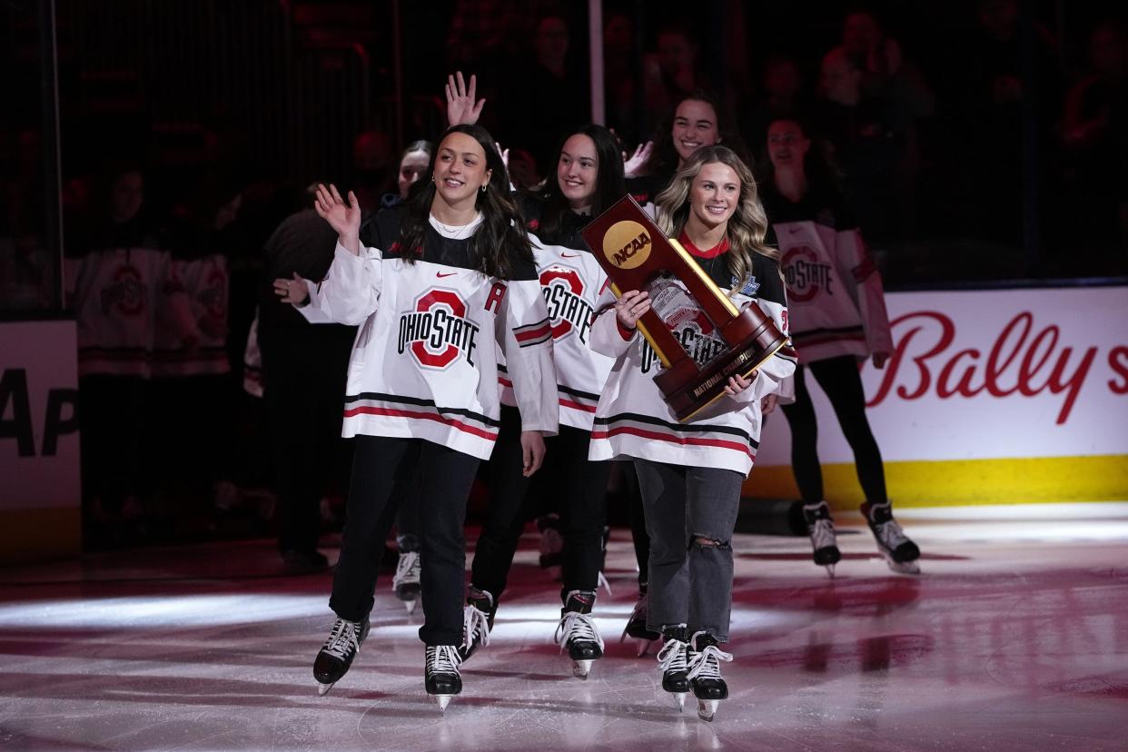Ohio State's Paetyn Levis holds the NCAA championship trophy as she leads her teammates out on the Nationwide Arena ice, where the Buckeyes were honored for their achievement.