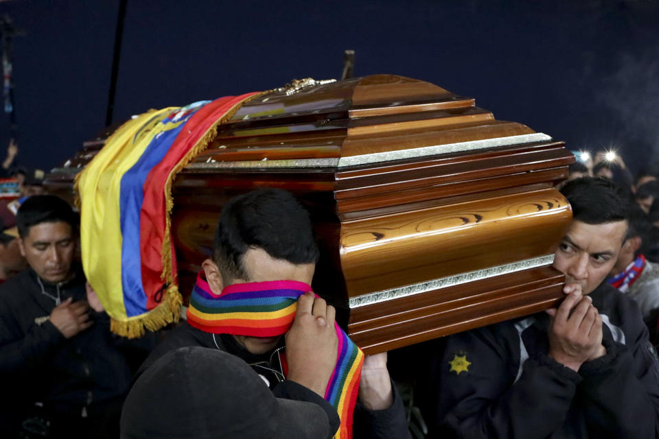 Police held captive by anti-government protesters, are forced to carry a coffin that contains the remains of a companion demonstrator who protesters say died during yesterday's national strike, in a procession inside the Casa de Cultura in Quito, Ecuador, Thursday, Oct. 10, 2019. An indigenous leader and four other people have died in unrest in Ecuador since last week, the public defender's office said Thursday. (AP Photo/Fernando Vergara)