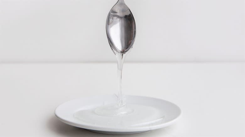 Corn syrup pouring off spoon