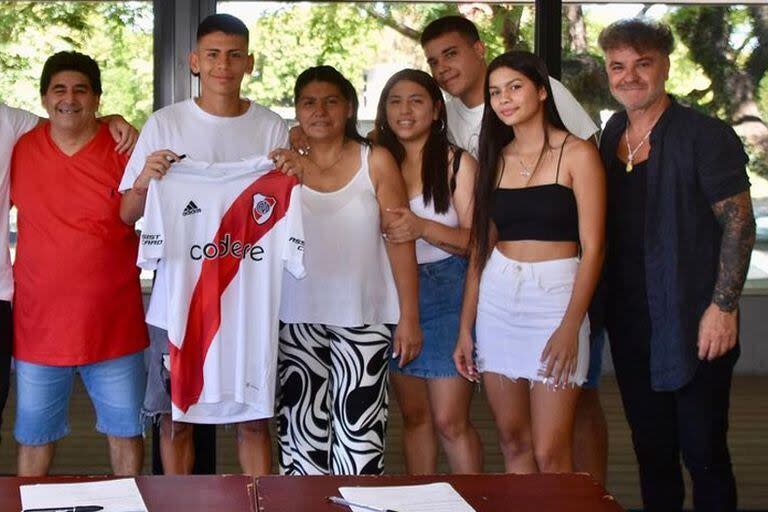 El Diablito Echeverri celebra la firma de su contrato con su familia y su representante, Enzo Montepaone, a la derecha