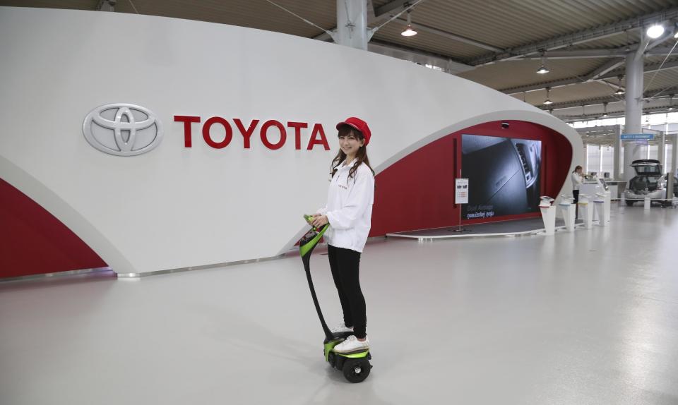 A Toyota gallery staff member takes a ride on Toyota's electric personal mobility robot "Winglet" in Tokyo Thursday, May 8, 2014. Toyota's fourth quarter profit dropped slightly despite higher vehicle sales and a weak yen as it spend more on research and development. Toyota Motor Corp. reported Thursday a January-March profit of 297 billion yen ($2.9 billion), down from 313.9 billion yen a year earlier. Quarterly sales rose 12.5 percent to 6.57 trillion yen ($64.5 billion). (AP Photo/Koji Sasahara)