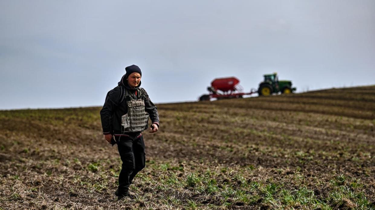 A farmer wears a bulletproof vest during crop sowing which takes place 30 km from the front line. Stock photo: Getty Images