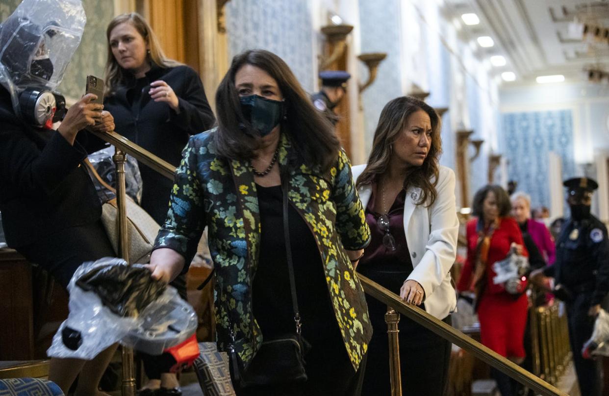 Reps. Diana DeGette, D-Colo., center, and Veronica Escobar, D-Texas, right, take cover as protesters disrupt the joint session of Congress to certify the Electoral College vote on Jan. 6, 2021. <a href="https://www.gettyimages.com/detail/news-photo/reps-diana-degette-d-colo-center-and-veronica-escobar-d-news-photo/1230454550?phrase=Electoral%20college%20vote%20insurrection%20Capitol&adppopup=true" rel="nofollow noopener" target="_blank" data-ylk="slk:Tom Williams/CQ-Roll Call, Inc via Getty Images;elm:context_link;itc:0;sec:content-canvas" class="link ">Tom Williams/CQ-Roll Call, Inc via Getty Images</a>