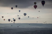 <p>Hot air balloons take to the skies as they participate in the mass assent at sunrise on the second day of the Bristol International Balloon Fiesta on August 11, 2017 in Bristol, England. (Photo: Matt Cardy/Getty Images) </p>