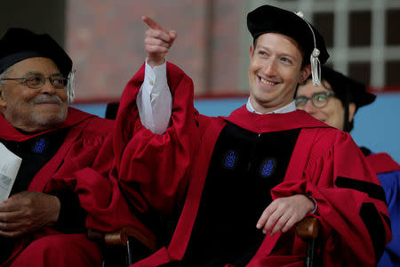 Facebook founder Mark Zuckerberg acknowledges a cheer from the crowd before receiving an honorary Doctor of Laws degree, as fellow honorary degree recipient actor James Earl Jones (L) looks on, during the 366th Commencement Exercises at Harvard University in Cambridge, Massachusetts, U.S., May 25, 2017. REUTERS/Brian Snyder
