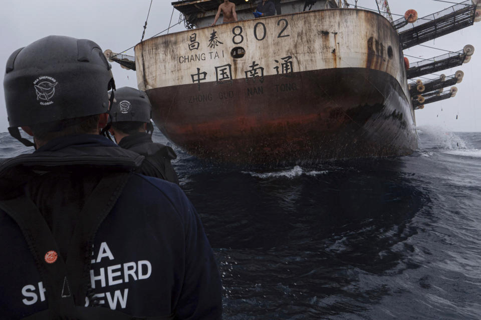 In this July 2021 photo provided by Sea Shepherd, crew members of the Ocean Warrior approach a Chinese-flagged vessel whose Indonesian crew said they had been stuck at sea for years. (Isaac Haslam/Sea Shepherd via AP)