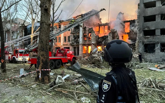 Emergency services personnel work at the site of a building that was damaged by a Russian missile strike