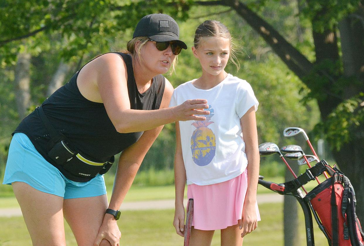 Niccole Mack of Watertown offers putting advice to her daughter Leni (10-11 girls) during the South Dakota Golf Association Junior Tour stop on Tuesday, July 9, 2024 at Cattail Crossing Golf Course in Watertown.