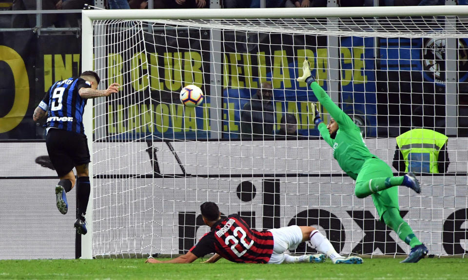 Inter Milan's Mauro Icardi, left, scores during the Serie A soccer match between Inter Milan and AC Milan at the San Siro Stadium in Milan, Italy, Sunday, Oct. 21 2018. Mauro Icardi's stoppage-time header gave Inter Milan a 1-0 win over AC Milan in the city derby on Sunday. (Daniel Del Zennaro/ANSA via AP)