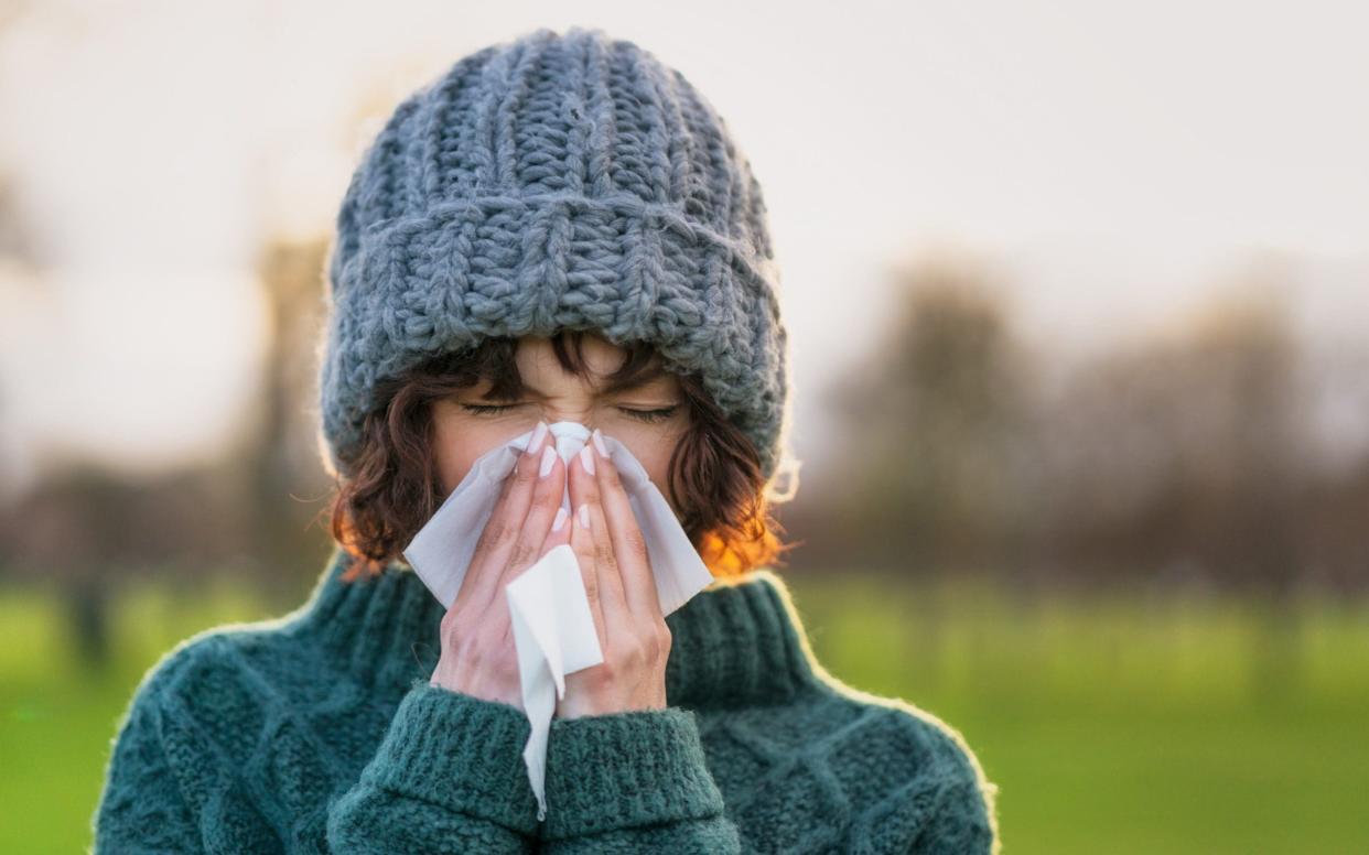 Woman sneezing - Getty