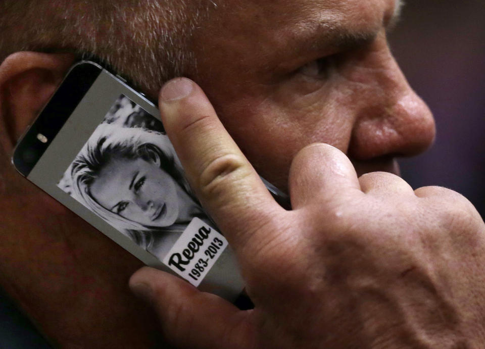 FILE — Former football player Mark Batchelor speaks on his mobile phone, bearing a photo of the late Reeva Steenkamp, as he sits in court after Oscar Pistorius' sentencing in Pretoria, South Africa, Tuesday, Oct. 21, 2014. Pistorius shot his girlfriend Reeva Steenkamp more than a decade ago in a Valentine's Day killing that jolted the world and shattered the image of a sports superstar. (AP Photo/Themba Hadebe, Pool, File)