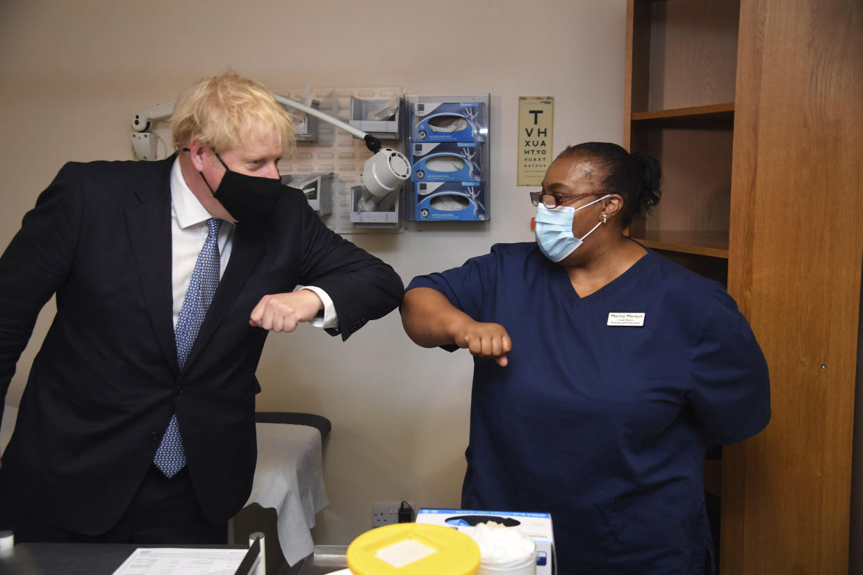 Britain's Prime Minister Boris Johnson, left, elbow bumps Lead Nurse Marina Marquis, during a visit to Tollgate Medical Centre in Beckton, East London, Friday July 24, 2020. (Jeremy Selwyn/Pool Photo via AP)