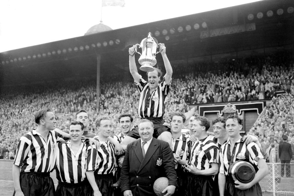 Newcastle captain Jimmy Scoular lifts the 1955 FA Cup aloft after a 3-1 victory over Manchester City (PA) (PA Archive)