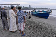 Local residents inspect the boat carrying hundreds of ethnic Rohingya people that landed on a beach in Lhokseumawe, Aceh province, Indonesia, Monday, Sept. 7, 2020. Almost 300 Rohingya Muslims were found on a beach in Indonesia's Aceh province Monday and were evacuated by military, police and Red Cross volunteers, authorities said. (AP Photo/Zik Maulana)