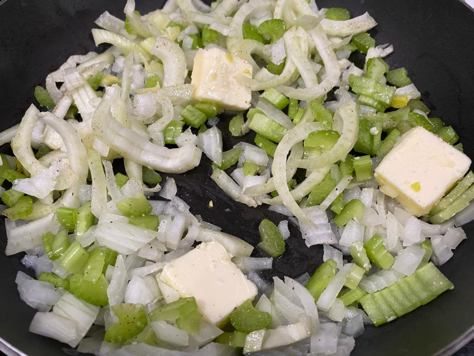 Chopped veggies, like celery and onions, cooking in a pan to make Sunny Anderson's stuffing