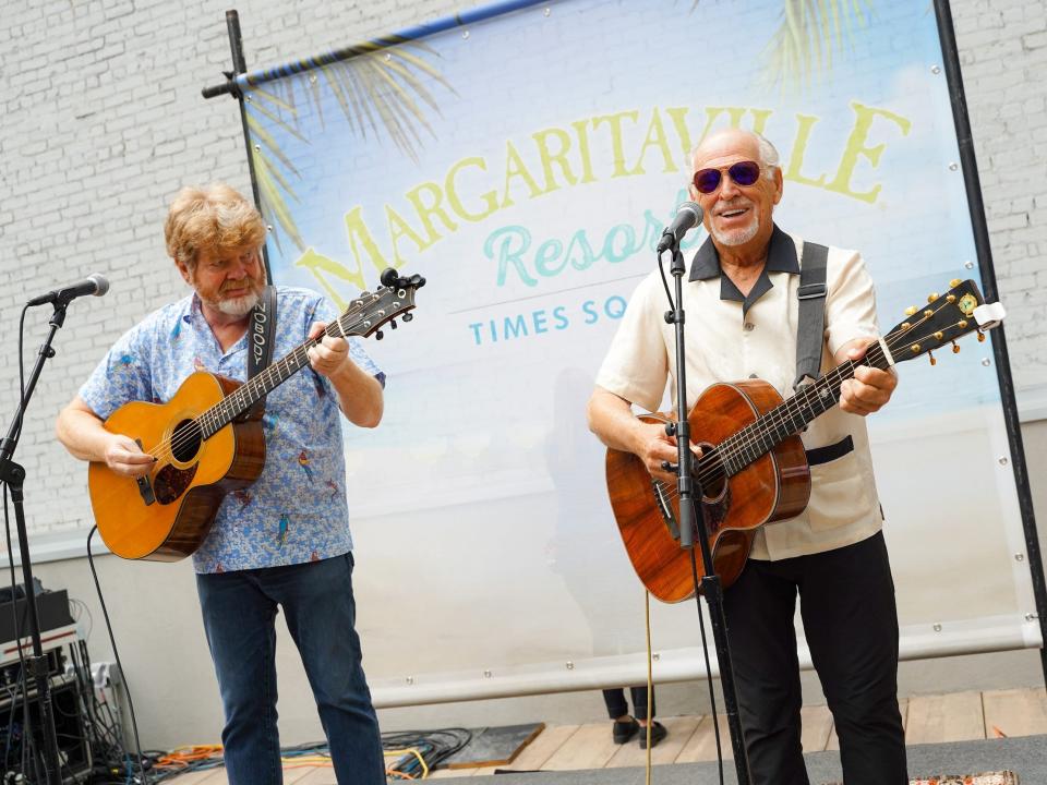 Jimmy Buffett and another musician sings and plays guitar at the Margaritaville Resort Times Square in New York City.