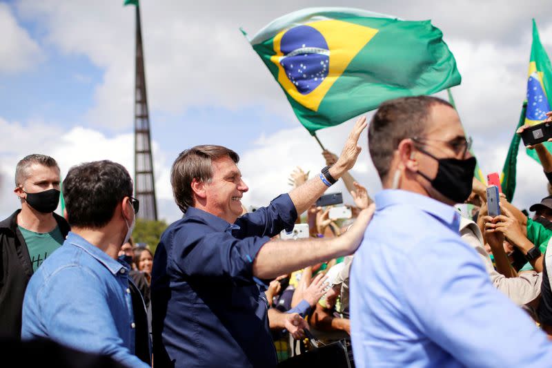 Brazil's President Jair Bolsonaro greets supporters during a protest in his favor in front of the Planalto Palace, amid the coronavirus disease (COVID-19) outbreak, in Brasilia