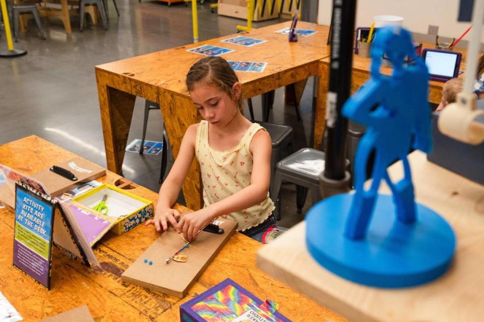 A 3D printed version of Taylor Swift sits on a shelf as Addyson Julien makes a Taylor Swift friendship bracelet inside the Makers Studio at Science City on Wednesday, July 5, 2023, in Kansas City. “Her music is really good,” Julien said. “My bracelet is really cool and I think I’m going to keep it because I’m a really big fan.”