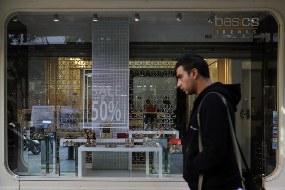 A man walks past a sign advertising a sale, in Beirut, Lebanon, Wednesday, Nov. 20, 2019. Lebanon’s worsening financial crisis has thrown businesses and households into disarray. Banks are severely limiting withdrawals of hard currency, and Lebanese say they don’t know how they’ll pay everything from tuitions to insurance and loans all made in dollars. Politicians are paralyzed, struggling to form a new government in the face of tens of thousands of protesters in the streets for the past month demanding the entire leadership go. (AP Photo/Bilal Hussein)