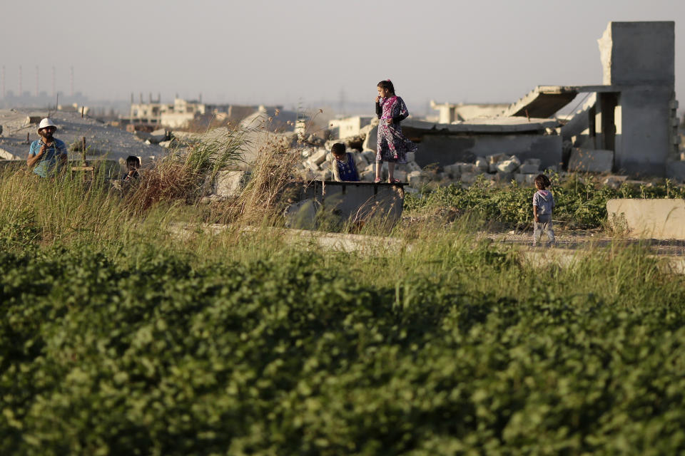 In this Friday, July 26, 2019 photo, children play next to their destroyed house on the outskirts of Aleppo, Syria. Rebels still frequently strike with shelling and mortars into Aleppo, killing civilians nearly three years after the government recaptured the city. Aleppo is a symbol of how President Bashar Assad succeeded in turning the tide in Syria’s long civil war with a series of wins, but it’s equally a symbol of how he’s been unable to secure a final victory. Half of Aleppo remains in ruins, and rebels remain on the doorstep. (AP Photo/Hassan Ammar)