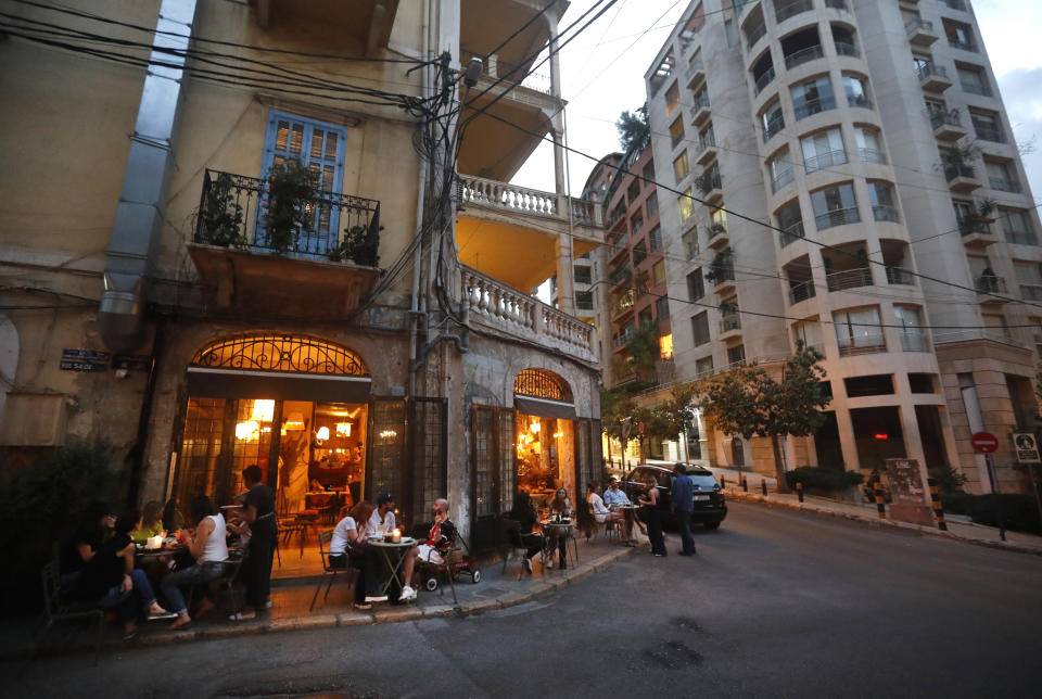 Customers have drinks on June 18, 2020, outside a restaurant owned by Walid Ataya, who also has a bakery, pizzeria, wine room and flower shop on a strategic intersection leading into one of Beirut's upscale neighborhoods. Ataya had to close all but the bakery and flower shop for nearly three months during Lebanon's strict and early lockdown imposed in March. (AP Photo/Hussein Malla)