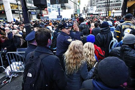 A New York Police officer tries to control the massive traffic of fans while they gather en masse at Super Bowl Boulevard zone ahead of Super Bowl XLVIII in New York February 1, 2014. REUTERS/Eduardo Munoz