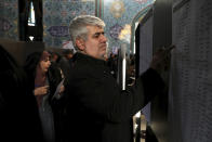 Voters fill out their ballots in the parliamentary elections at a polling station in Tehran, Iran, Friday, Feb. 21, 2020. Iranians began voting for a new parliament Friday, with turnout seen as a key measure of support for Iran's leadership as sanctions weigh on the economy and isolate the country diplomatically. (AP Photo/Ebrahim Noroozi)