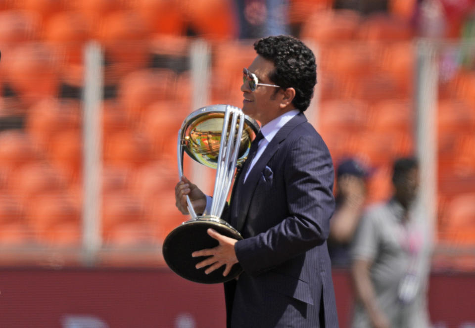 Indian Cricketer and ICC World Cup 2023 global ambassador Sachin Tendulkar walks out with the Men's Cricket World Cup Trophy before the start of the ICC Cricket World Cup opening match between England and New Zealand in Ahmedabad, India, Thursday, Oct. 5, 2023. (AP Photo/Ajit Solanki)