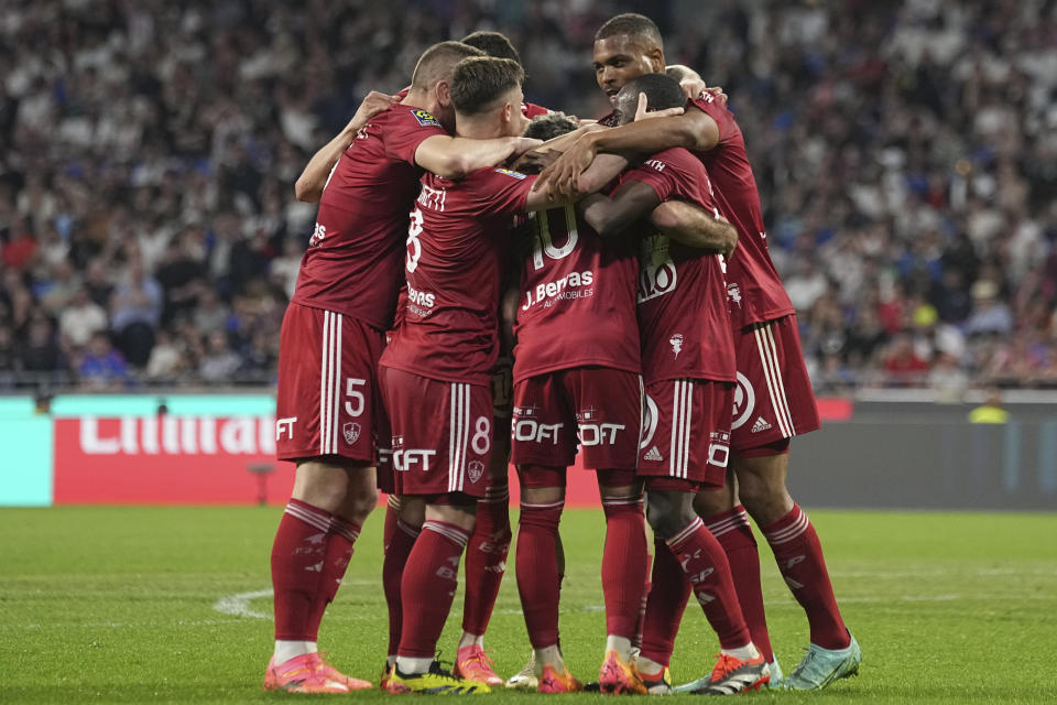 Brest's Romain Del Castillo is congratulated after scoring his side's 3rd goal during a French League One soccer match between Lyon and Brest at the Groupama stadium, outside Lyon, France, Sunday, April 14, 2024. (AP Photo/Laurent Cipriani)