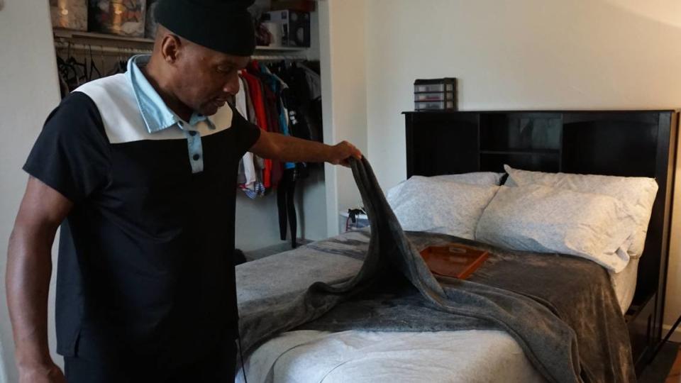 Former 40 Prado Homeless Services Center client Malcolm Drisdon, 55, stands in his Atascadero home with bedding donated by St. Stephen’s Episcopal Church.