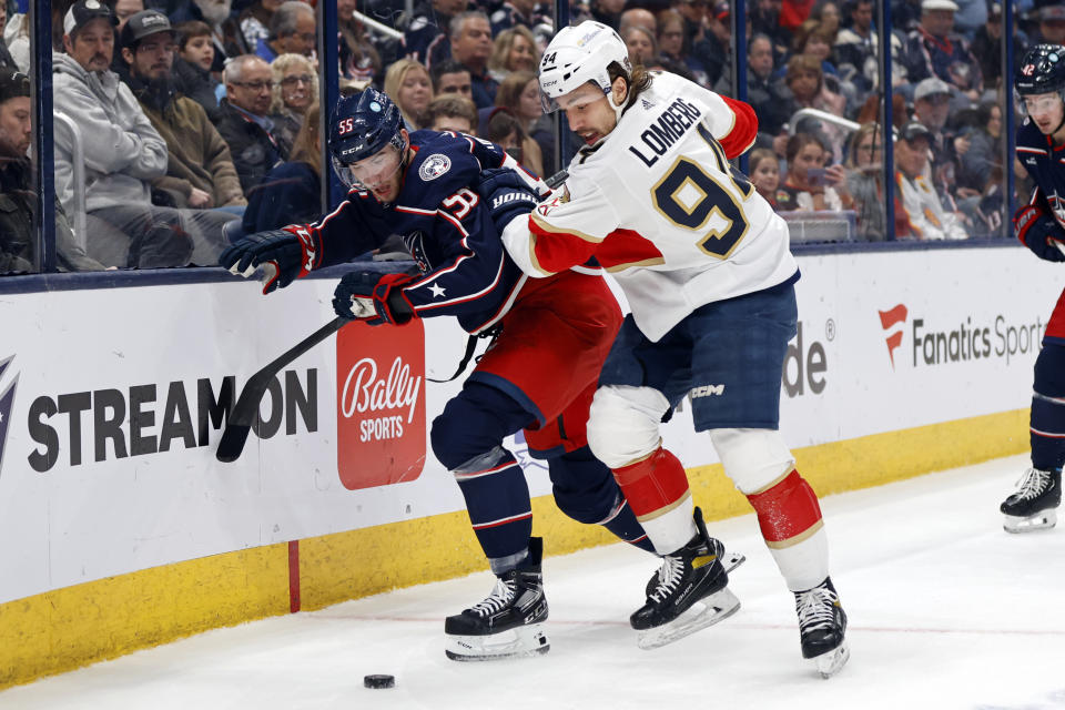 Florida Panthers forward Ryan Lomberg, right, works for the puck in front of Columbus Blue Jackets defenseman David Jiricek during the first period of an NHL hockey game in Columbus, Ohio, Sunday, Dec. 10, 2023. (AP Photo/Paul Vernon)