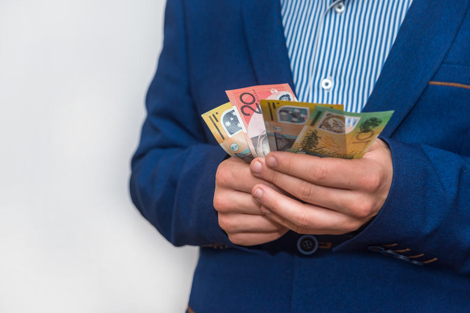 Male hands holding australias dollar banknotes closeup