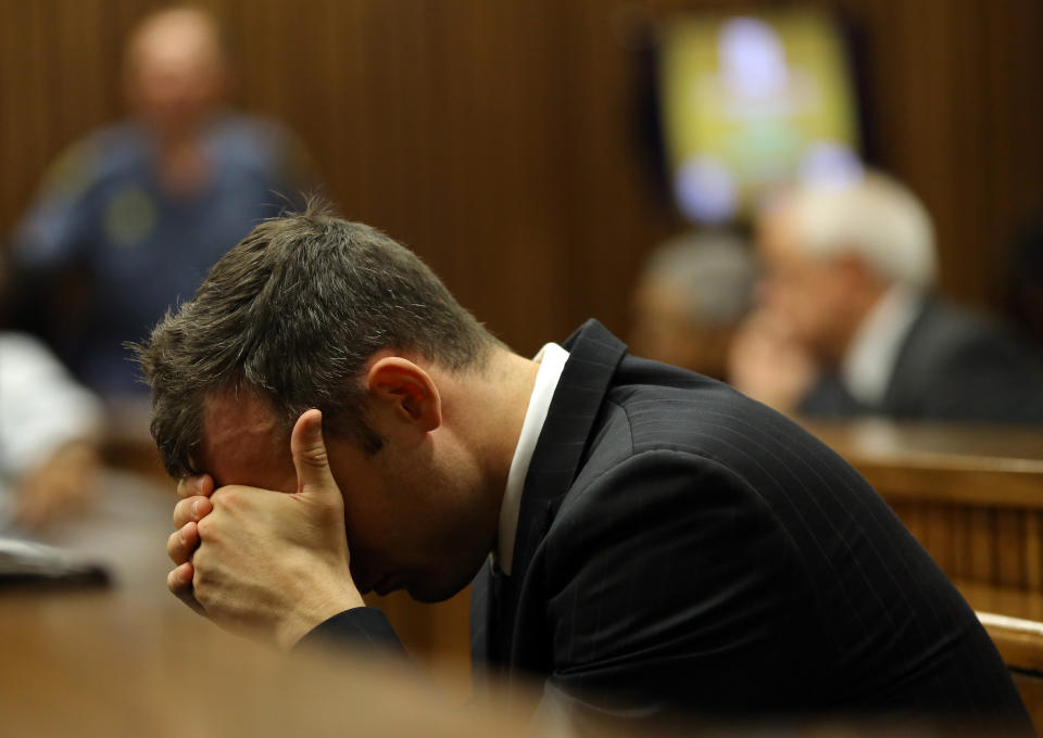 Oscar Pistorius places his head in his hands as he listens to the cross examination during his trial in court in Pretoria, South Africa, Thursday March 13, 2014. Pistorius is charged with the shooting death of his girlfriend Reeva Steenkamp on Valentines Day in 2013. (AP Photo/Themba Hadebe, Pool)
