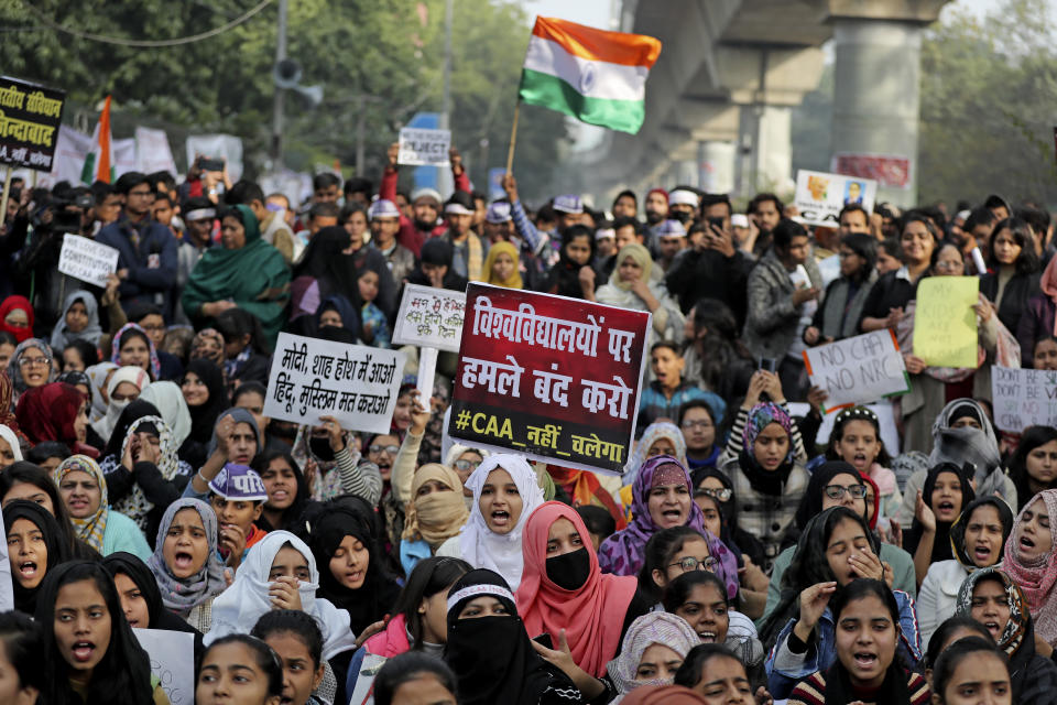 Indian students of the Jamia Millia Islamia University and locals participate in a protest demonstration against a new citizenship law in New Delhi, India, Saturday, Dec. 21, 2019. Critics have slammed the law as a violation of India's secular constitution and have called it the latest effort by the Narendra Modi government to marginalize the country's 200 million Muslims. Modi has defended the law as a humanitarian gesture. Placard center reads "Stop attacking universities." (AP Photo/Altaf Qadri)