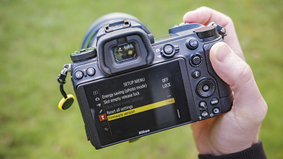 Nikon Z6 ii camera in the hand with its firmware version displayed on rear screen