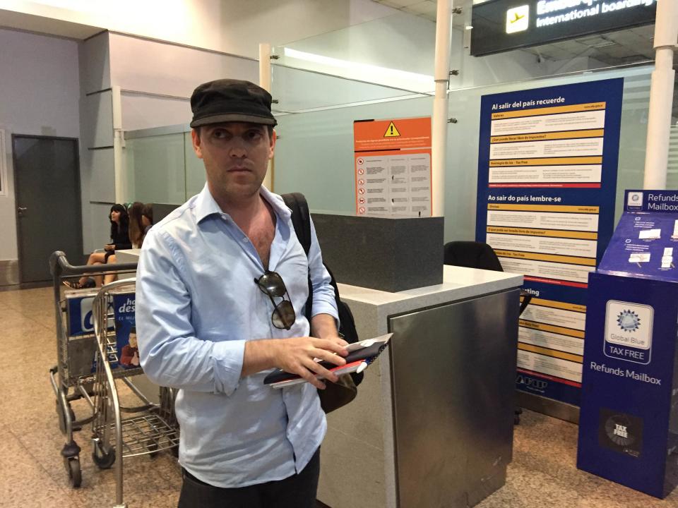 Argentine journalist Damian Pachter, who works for the Buenos Aires Herald newspaper, waits before taking a flight out of the country at Buenos Aires' airport, early January 24, 2015. Pachter, the first journalist who reported on the death of Argentine prosecutor Alberto Nisman, who had made a serious accusation against President Cristina Fernandez de Kirchner, said on Saturday that left the country in fear for his life. Nisman, who was investigating the deadly 1994 bombing of a Jewish community center in Buenos Aires, claimed last week that President Fernandez de Kirchner opened a secret back channel to Iran to cover up Tehran's alleged involvement in the bombing and gain access to Iranian oil needed to help close Argentina's $7 billion per year energy deficit. REUTERS/Adrian Bono (ARGENTINA - Tags: POLITICS CRIME LAW)