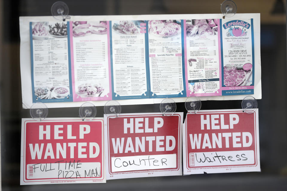 Help wanted signs hang below menus at a restaurant in the Newport section of Jersey City, N.J., Wednesday, May 2, 2018. (AP Photo/Julio Cortez)