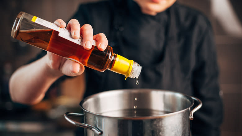 Pouring vinegar into cooking pot