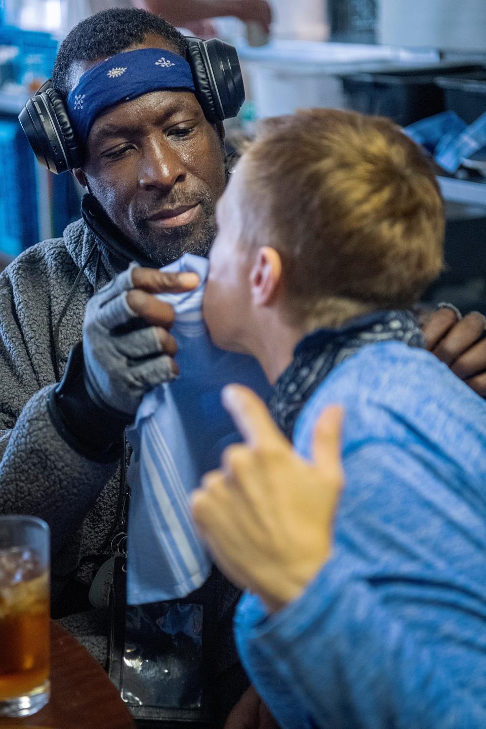 Jeffery Glenn wipes the face of his fiancee, Christie, while they eat at Haywood Street Congregation, November 8, 2023.