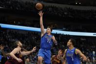 Dallas Mavericks guard Luka Doncic (77) shoots as Cleveland Cavaliers' Kevin Love, left, and Dwight Powell (7) look on in the first half of an NBA basketball game in Dallas, Monday, Nov. 29, 2021. (AP Photo/Tony Gutierrez)